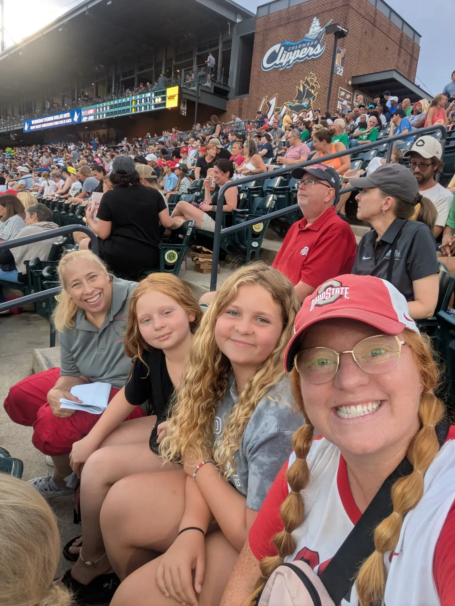 four alumni women smiling for a photo at a game