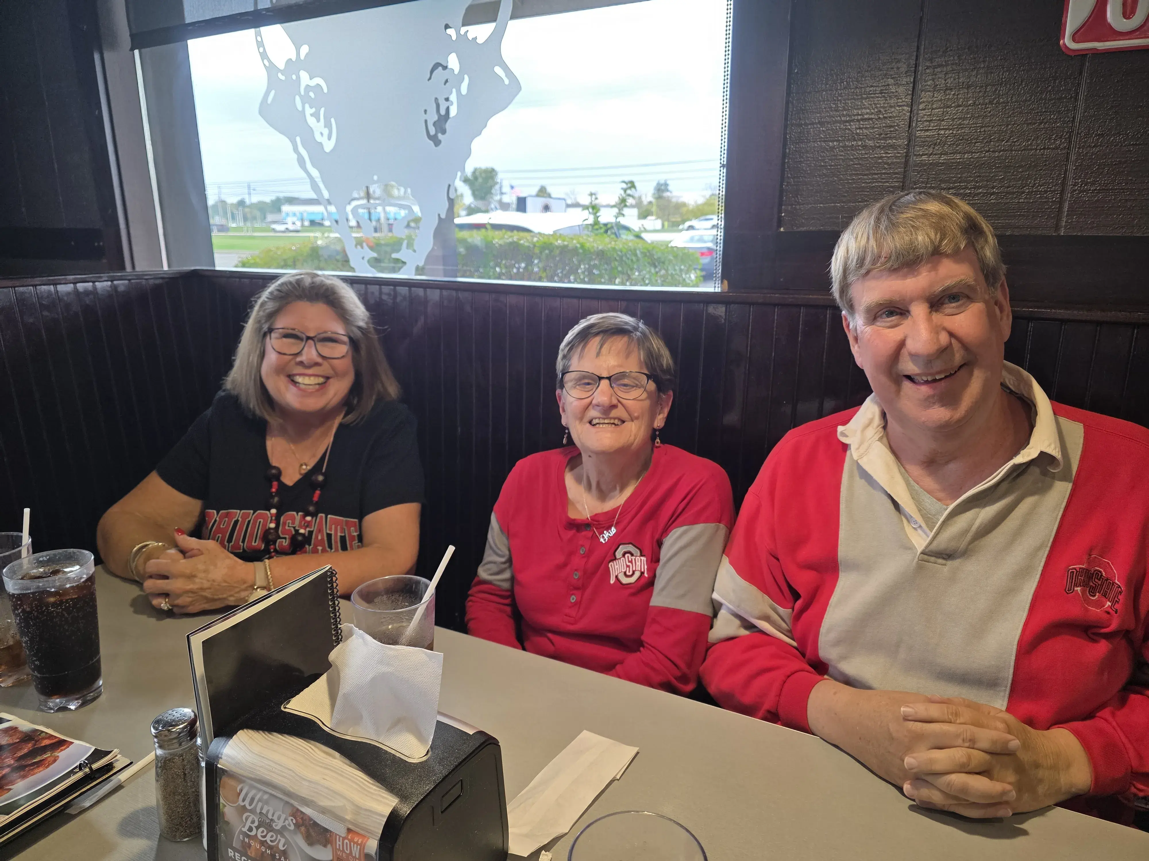 three alumni smiling for a photo at dinner