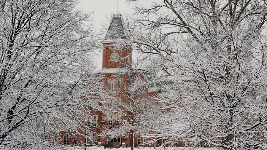 Snowy picture of Ohio State's campus with a building in the background.