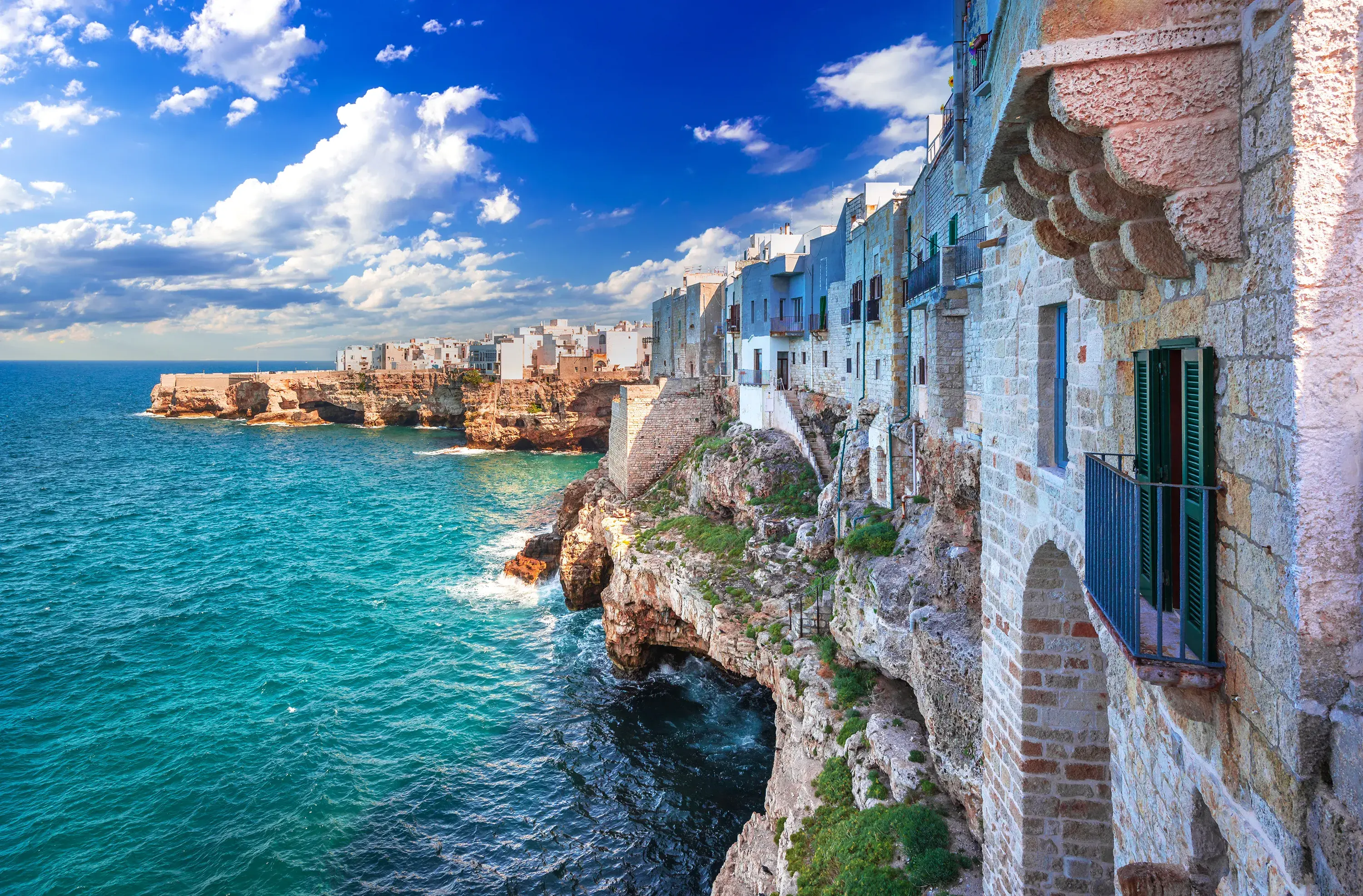 Cliffside stone houses overlooking the turquoise Adriatic Sea in Polignano a Mare, Apulia.