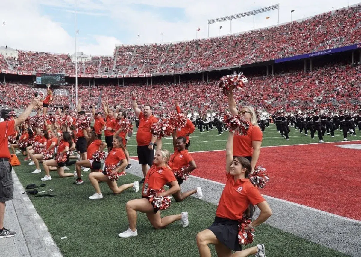 cheerleaders on the football field at the shoe holding up their pom poms