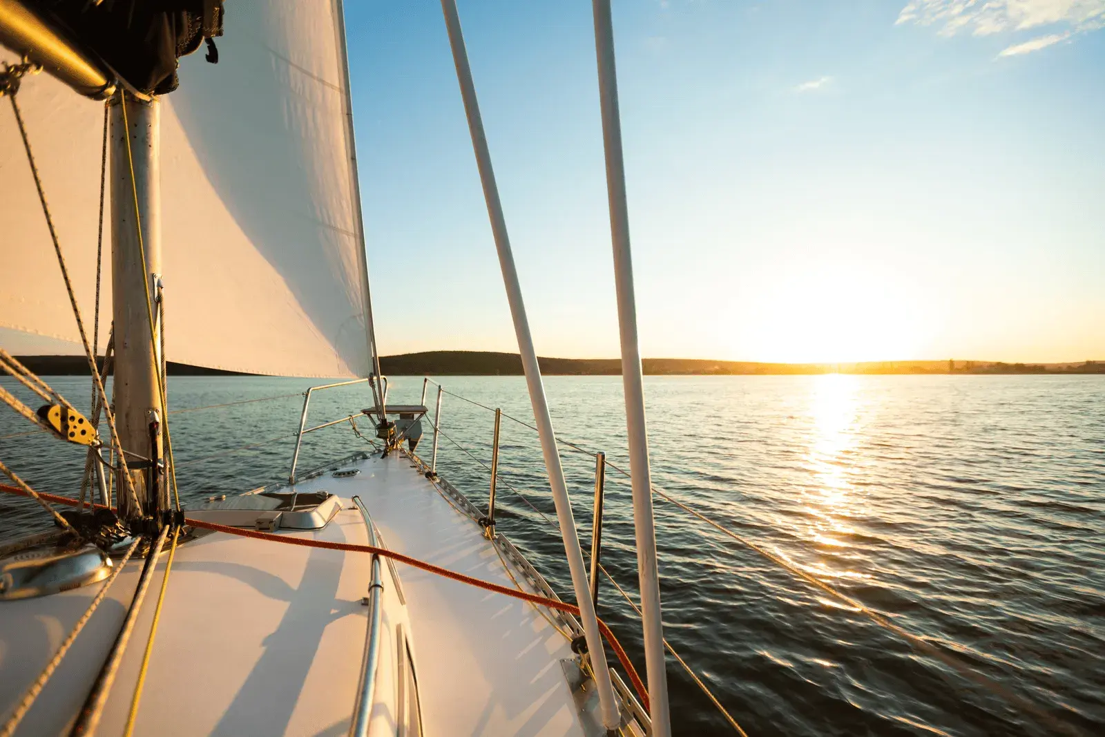 Front of a sailboat and water in the distance.