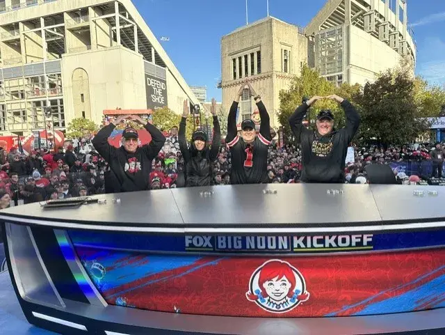 Alumni doing the O-H-I-O sign with their arms