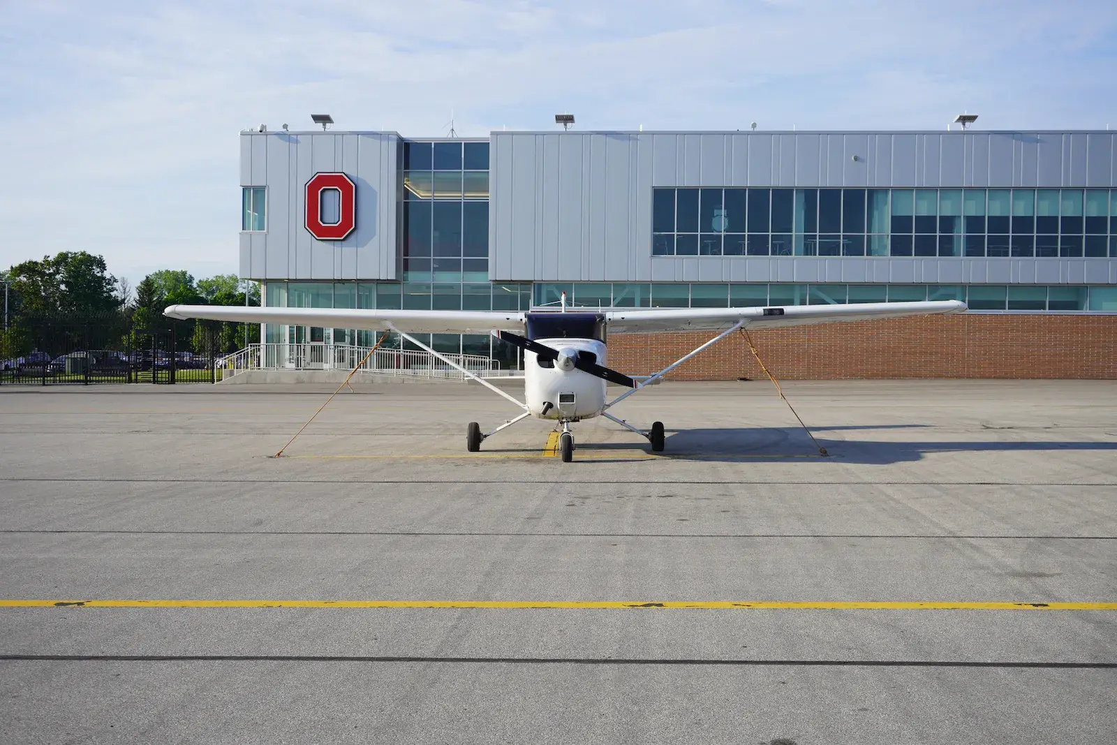 Plane with Ohio State branded building behind it