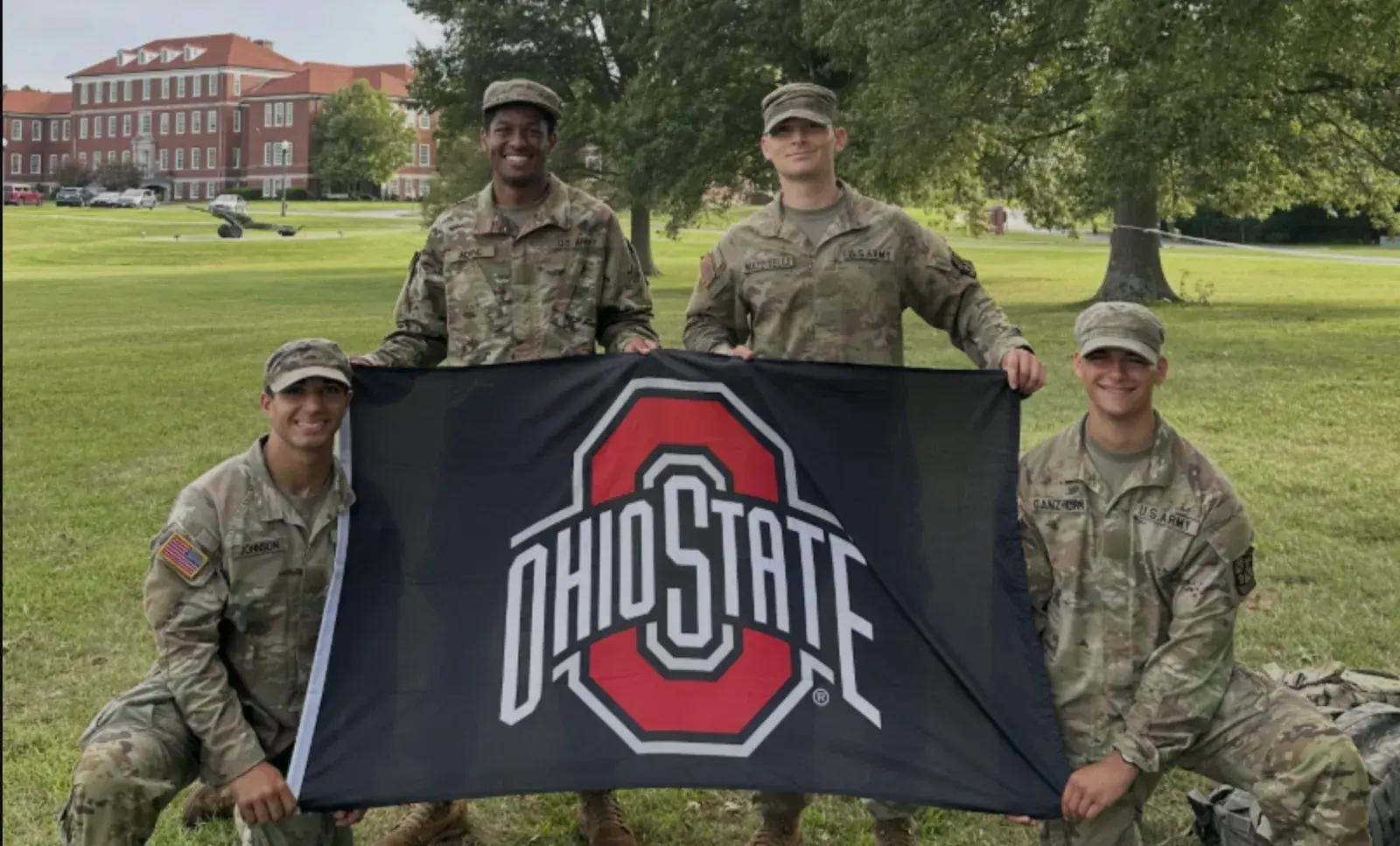 group of army rotc members holding ohio state flag.