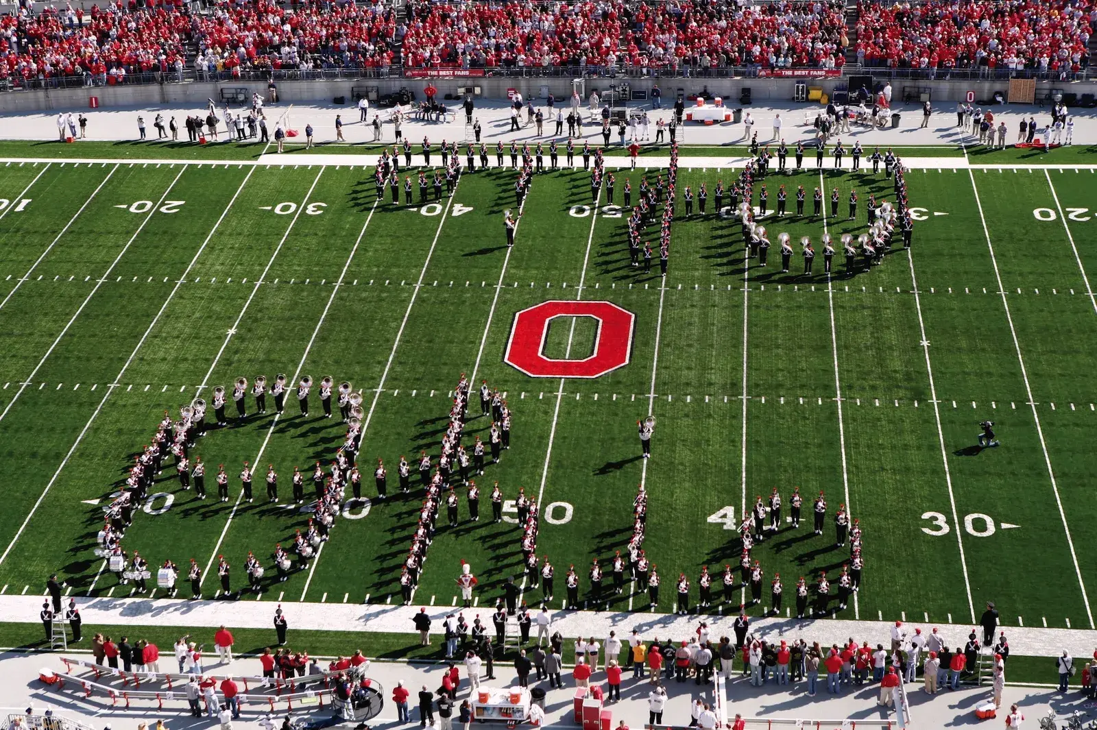 School band creating O-H-I-O sign on football field.