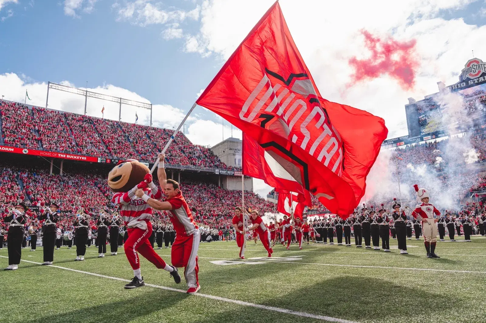 Brutus on Ohio Stadium field with flag.