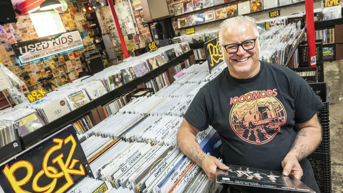 Used Kids owner Greg Hall laughs as he is photographed in the record store.