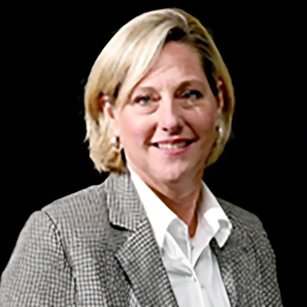 Leslie smith in a gray and white checkered suit coat smiling for a portrait