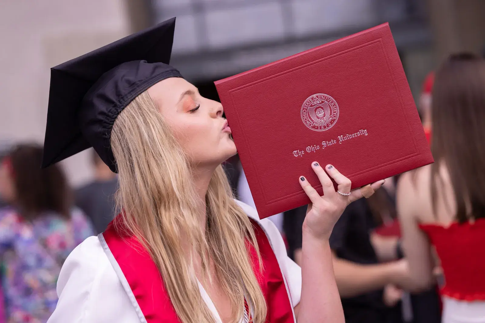 buckeye graduate kissing their diploma