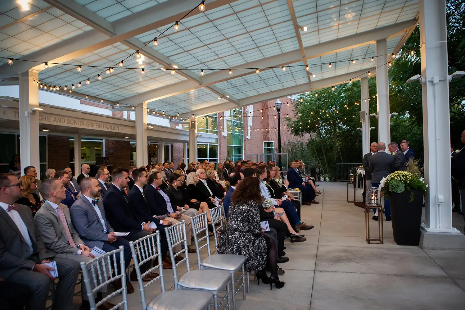 dozens of people gathered for an outdoor wedding