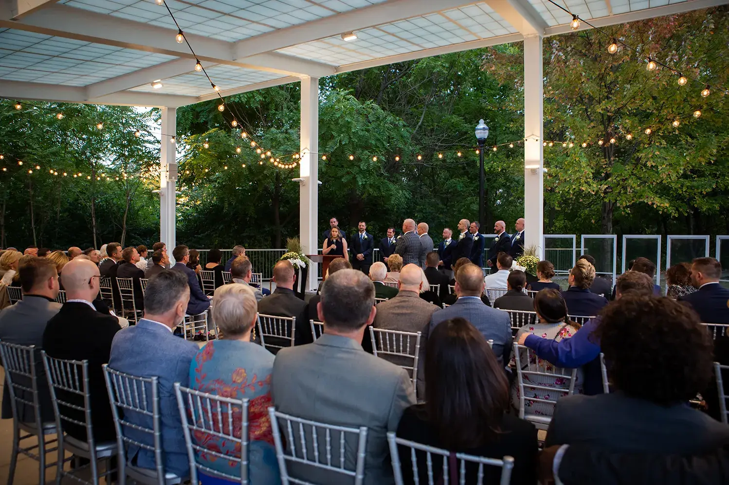 dozens of people gathered for an outdoor wedding