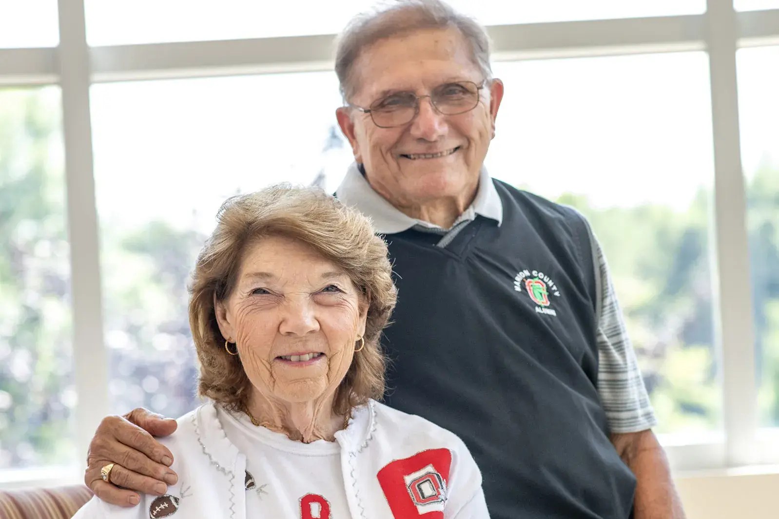 husband and wife smiling while wearing ohio state apparel 