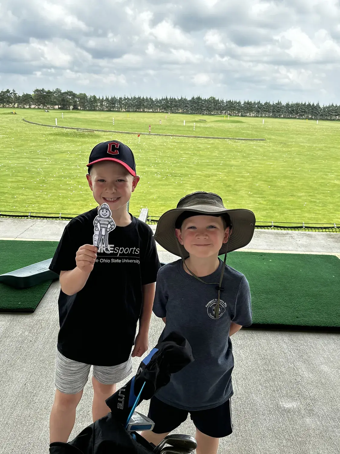 Two boys, one holding Brutus, standing by a golf course in Dublin, Ohio.