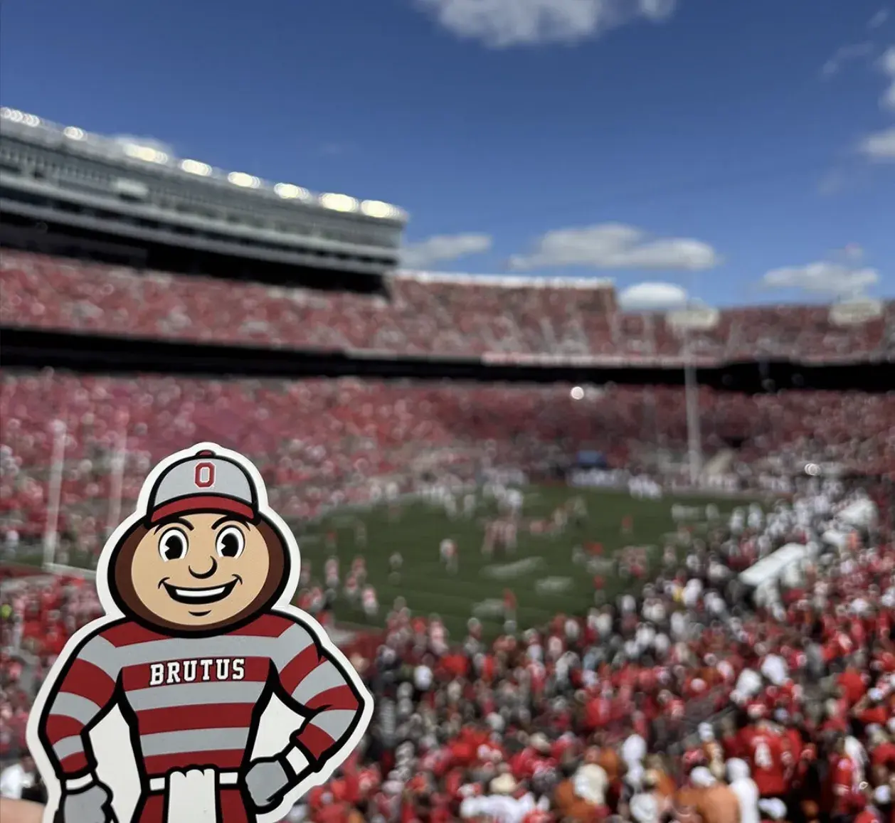 Brutus in Ohio Stadium with a football game in the background.