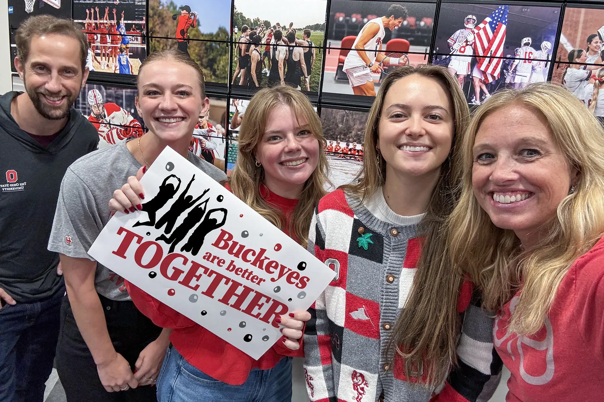 Five people smiling together, one holding a sign that says 'Buckeyes are better TOGETHER,' with a sports-themed background featuring Ohio State University imagery.