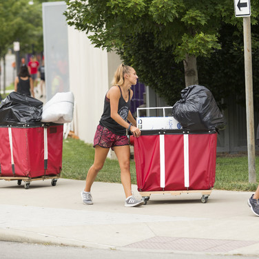 You won’t have to move anything alone. Second-year students Julia Spencer, red shorts, and Christine DelNano, far right, lead a parade of student helpers.