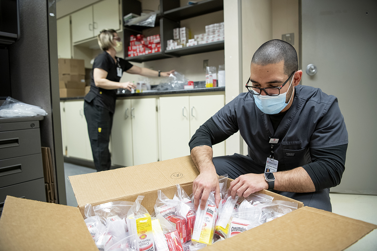 Ohio State staff members assemble packages of cough medicine and acetaminophen.