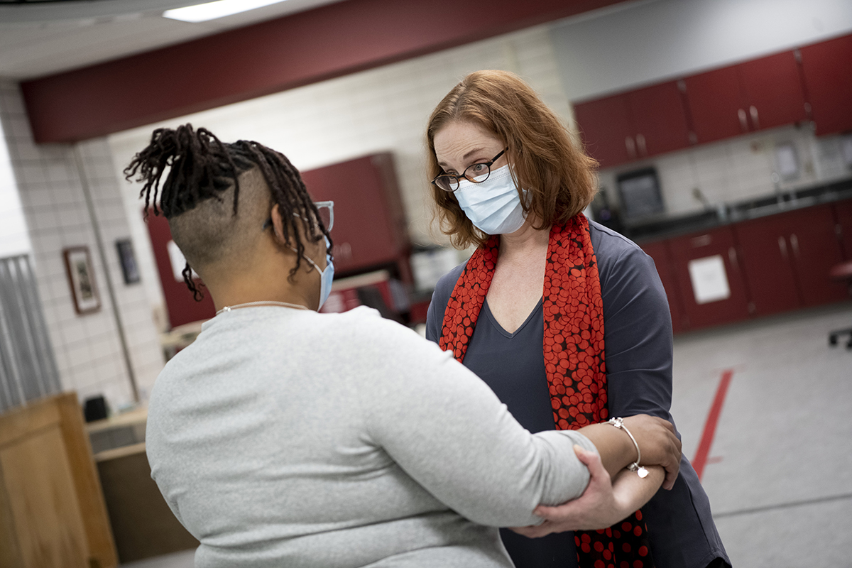 Rehabiliitation therapist Lise Worthen-Chaudhari holds the arms of patient Nakia Bridges as the two work through a therapeutic exercise centered around dance.