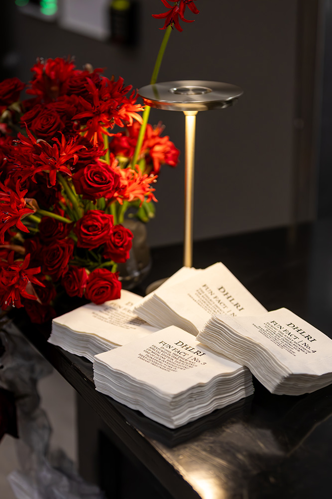Napkins on a table next to a bouquet of flowers.