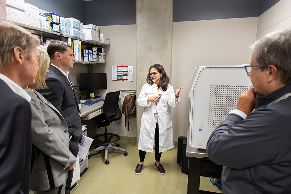 Woman in a lab coat showing an item in an lab