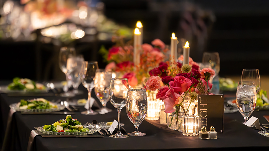 Table setting at an event with pink and red florals.