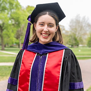 Photo of Lydia Kotowski, an Ohio State graduate, standing in a cap and gown and smiling