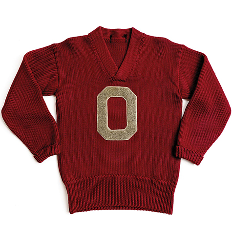 A scarlet sweater with a gray Block 0 is laid out as if the wearer is standing with hands on hips.