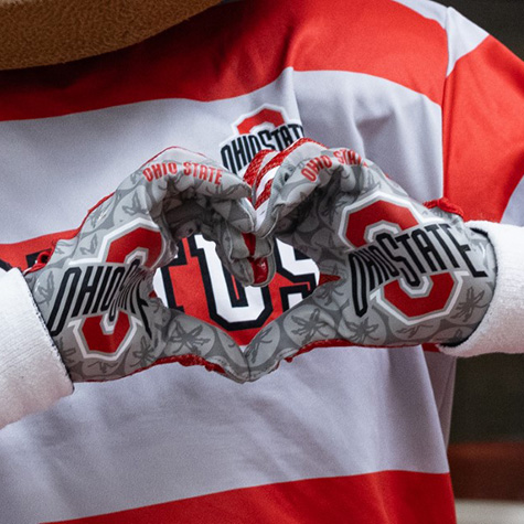 Brutus Buckeye making a heart with his hands