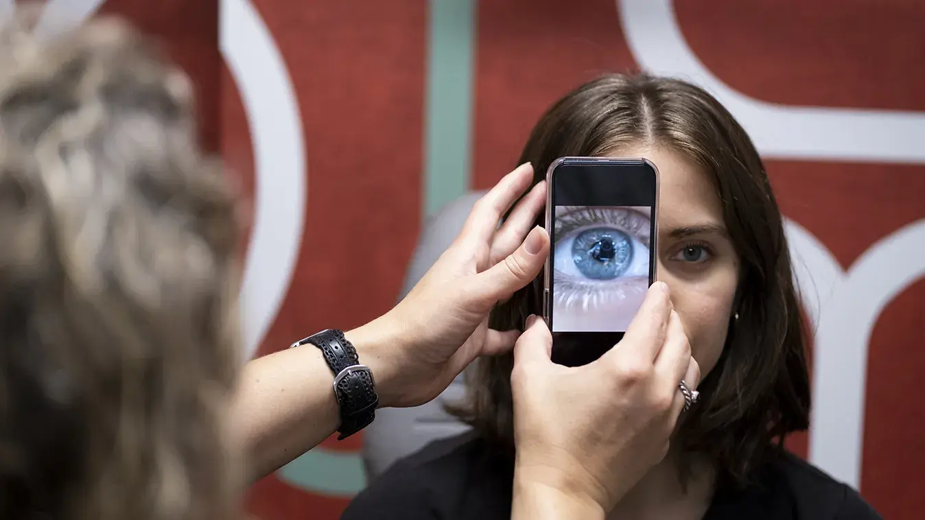 woman using an iphone to scan a patient's cornea