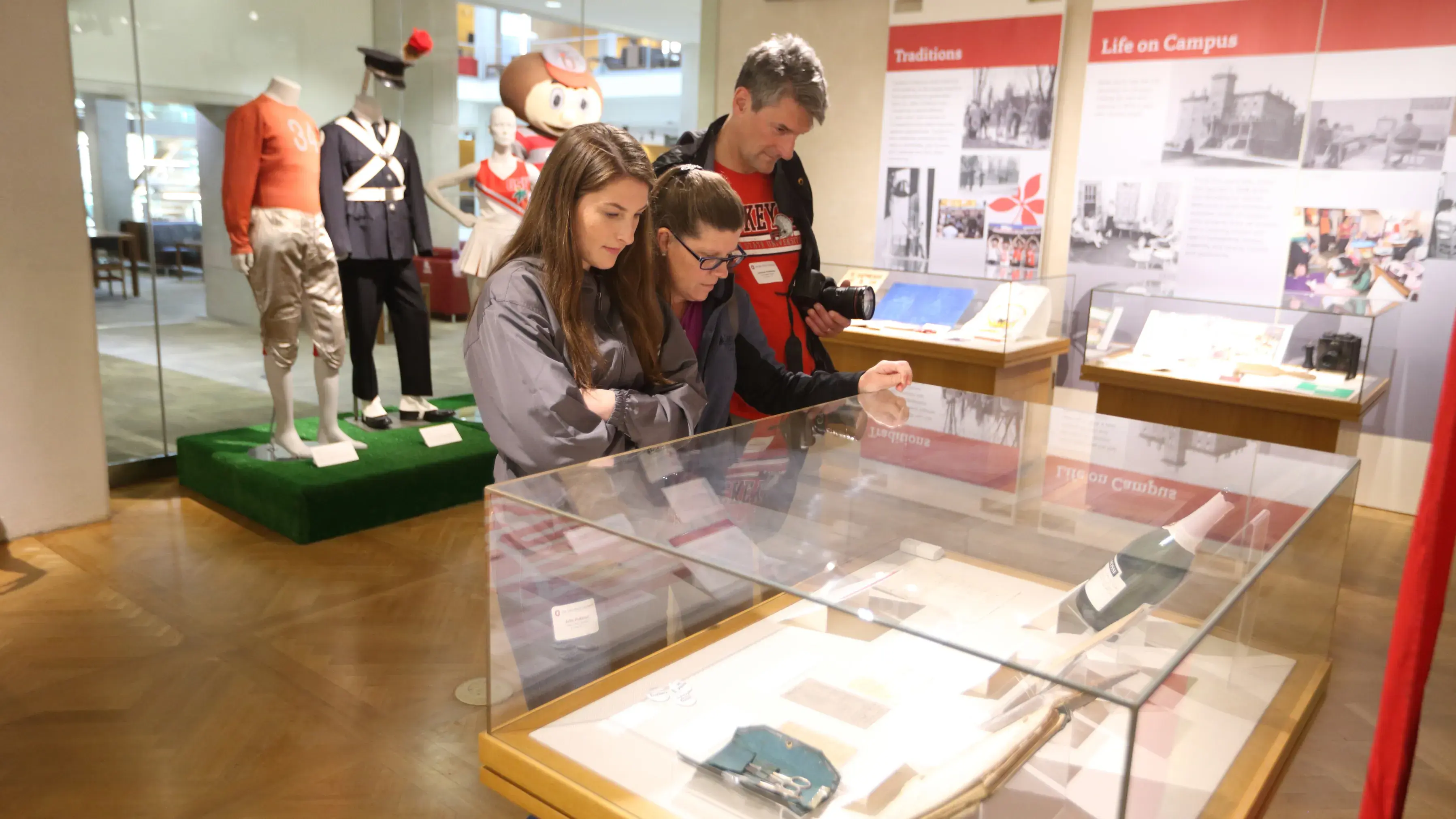 parents and student exploring the history displays at Thompson Library on osu's campus