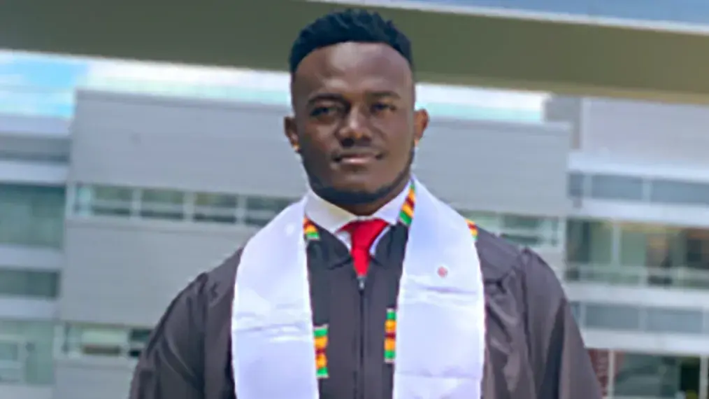 Emmanuel Adu wearing graduation outfit posing for a portrait