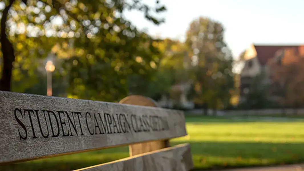 view of ohio state's campus with a donated wooden bench in the foreground