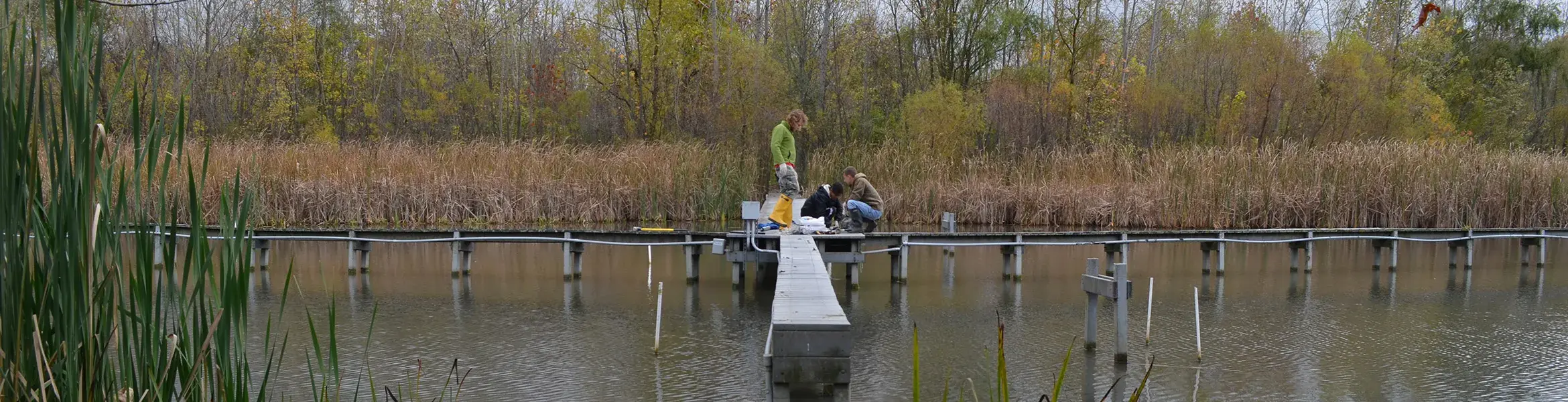 students getting ready to run tests on a small narrow dock over the water
