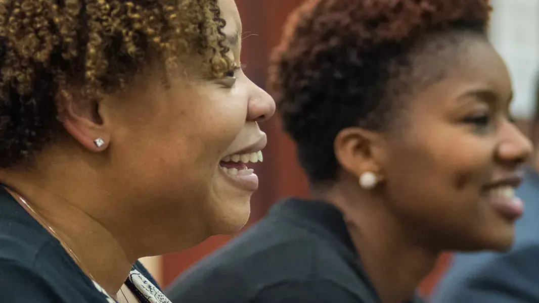 graduate students sitting side by side smiling