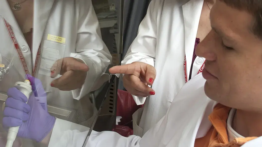  two people in lab coats using testing equipment in a lab