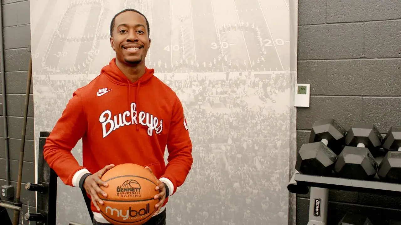 AJ Bennett holding a basketball wearing a buckeys hoodie