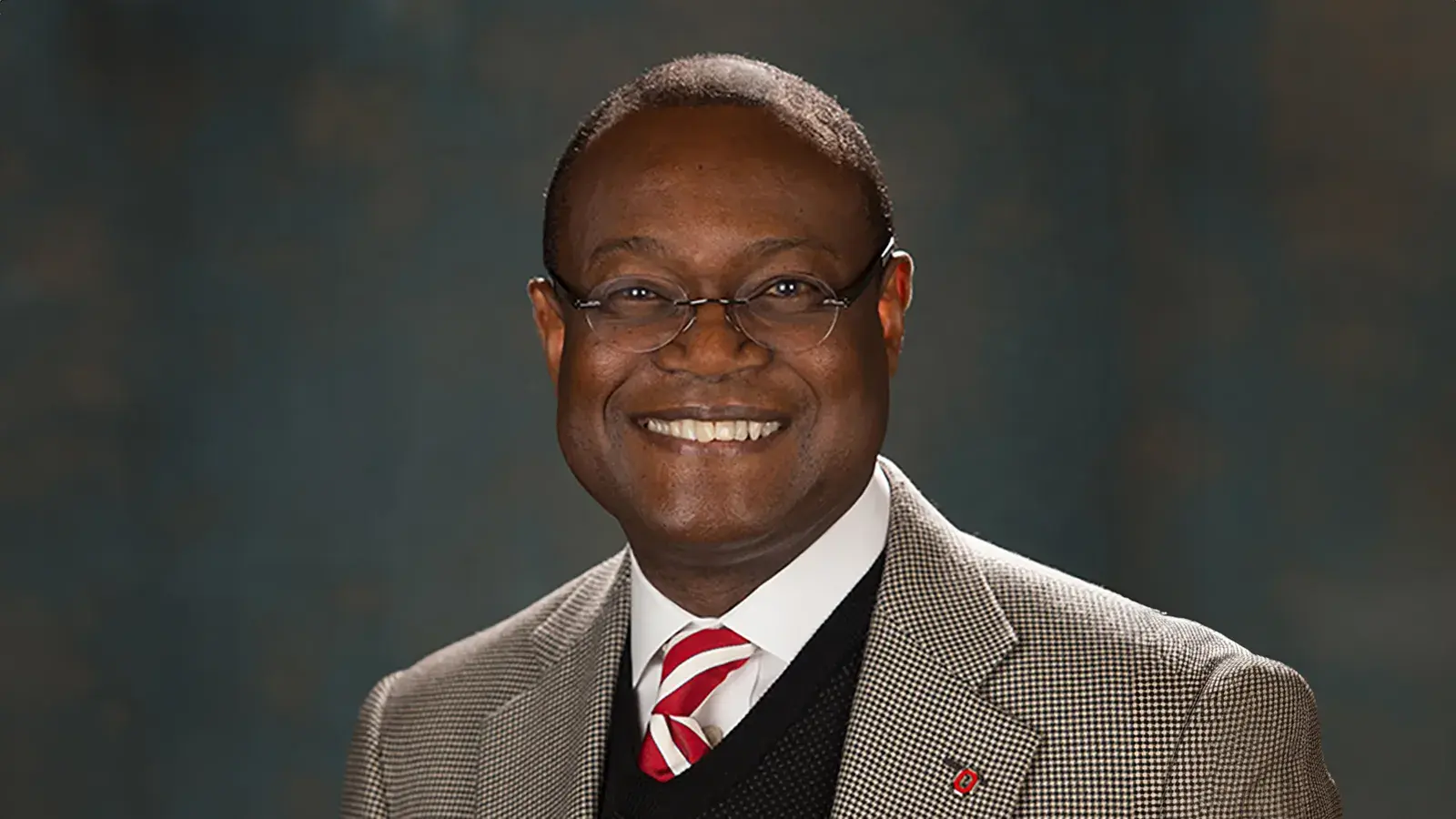 W. Ray Persons wearing a suit and tie posing for a portrait