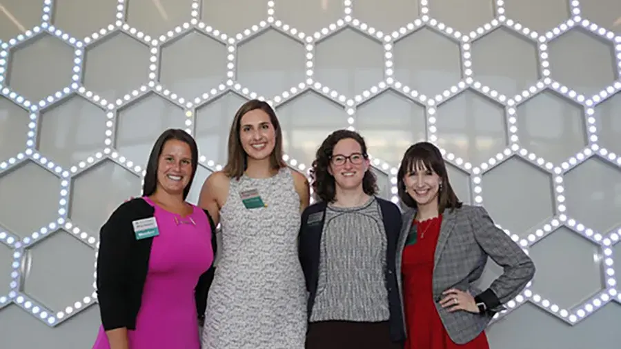 Four women posing in the CBE building