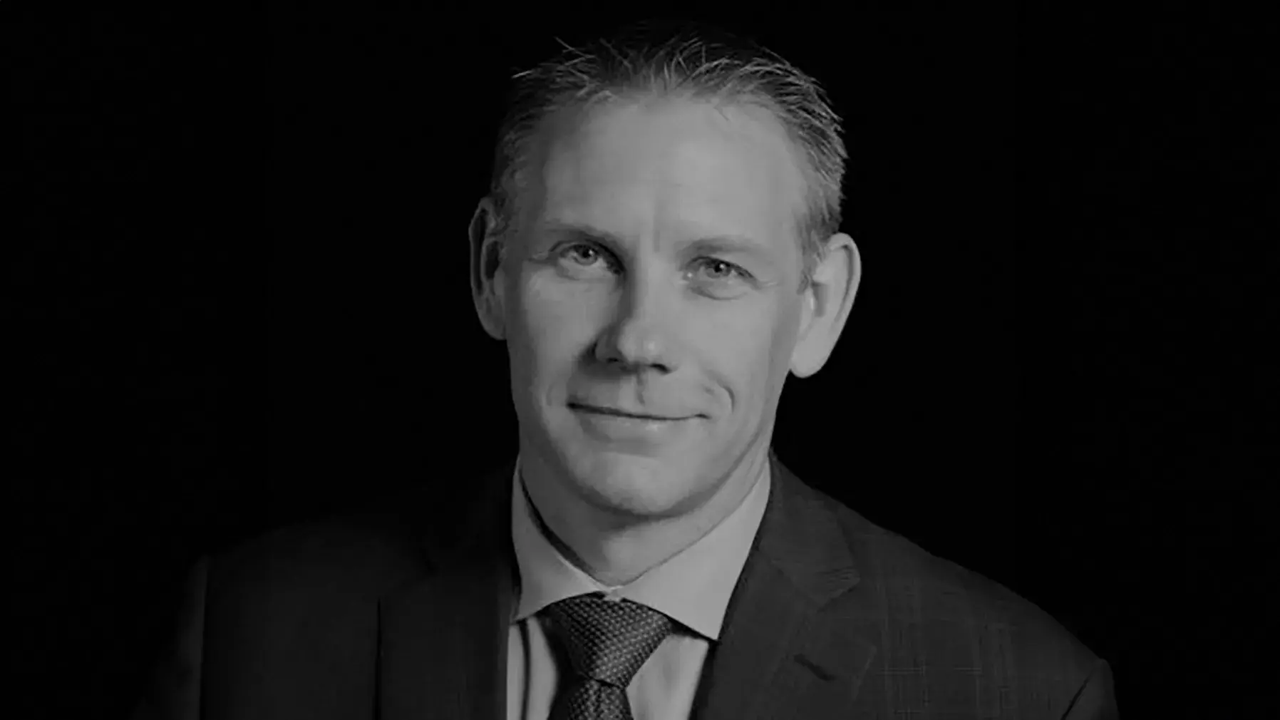 black and white portrait of Anthony Padgett wearing a dark suit and tie