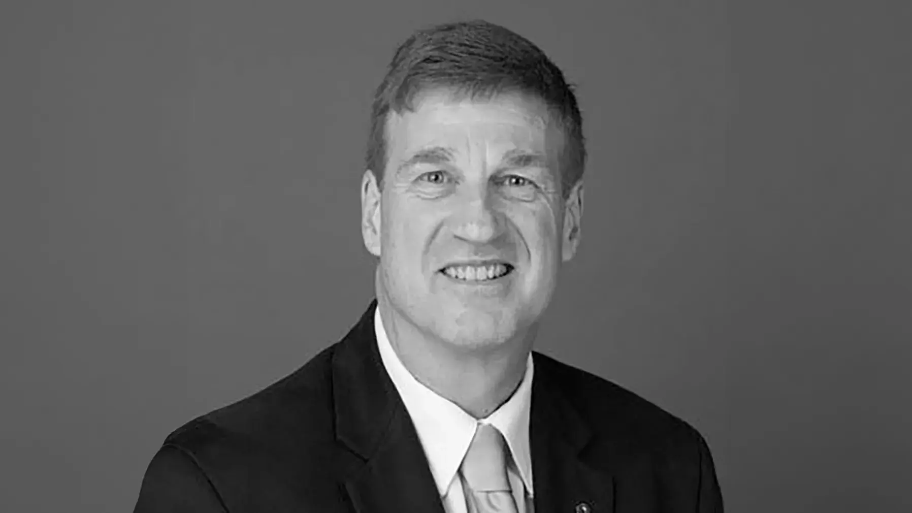 black and white portrait of Patrick L. Green, PhD wearing a dark suit and light colored tie