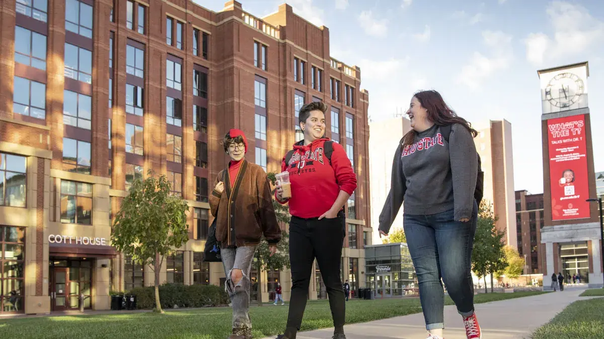 Three students walking together across campus