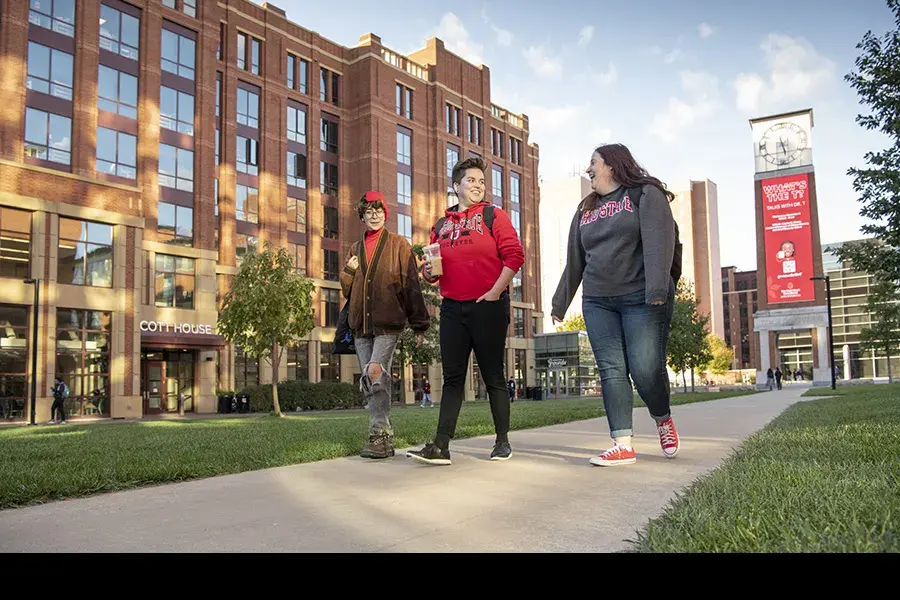 Three students walk across campus