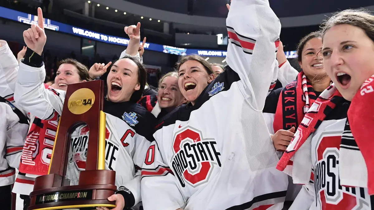The women's hockey team celebrates as they hold the national championship trophy