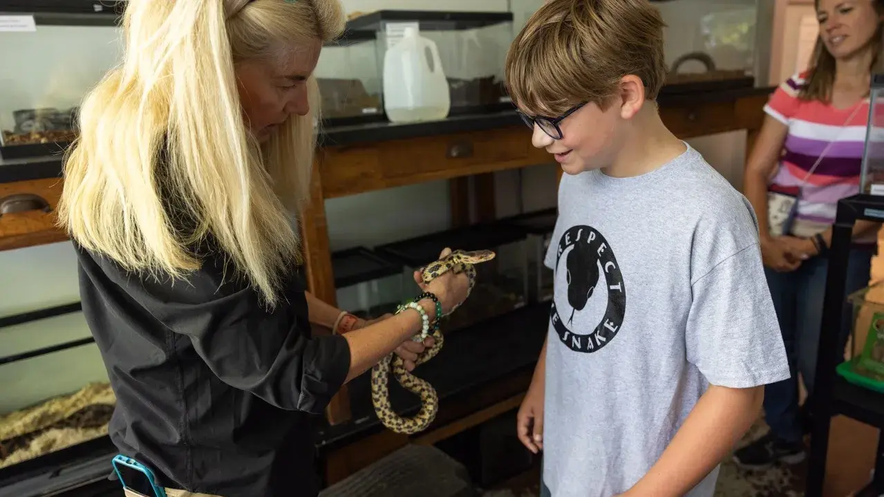 Women holds snake while Spencer watches