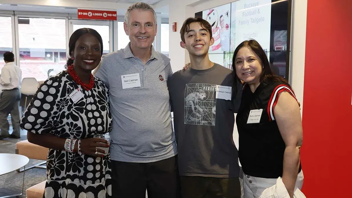 Two women and two men pose and smile for the camera