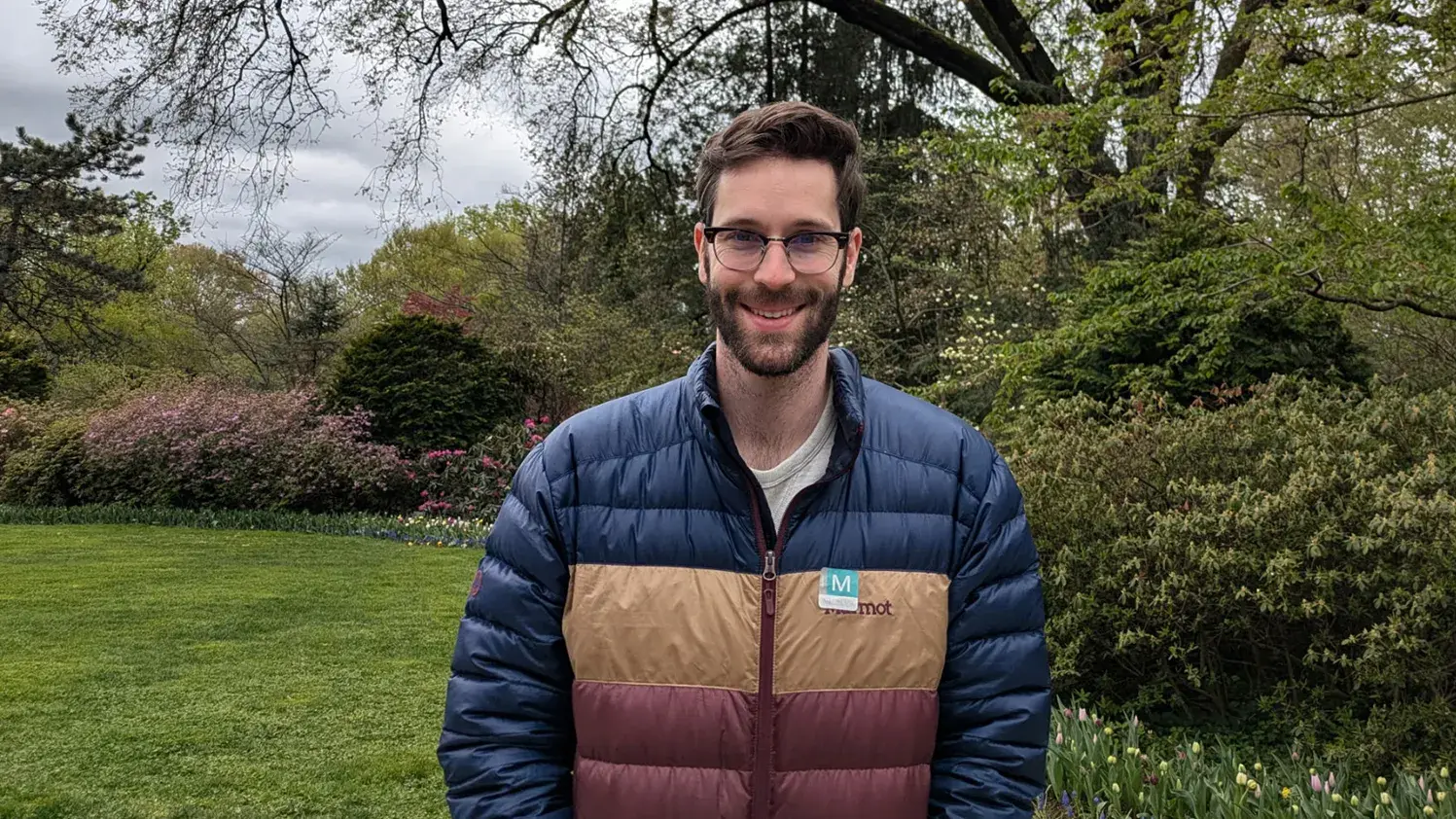 Michael Jarrell stands outside in a park smiling for the camera