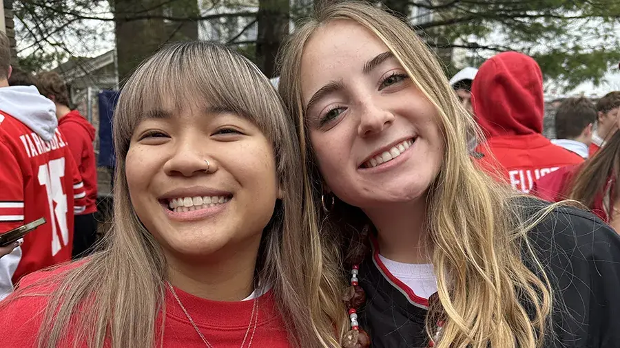 Katalina and a friend posing closely together at an outdoor crowd event, wearing Ohio State sports apparel.