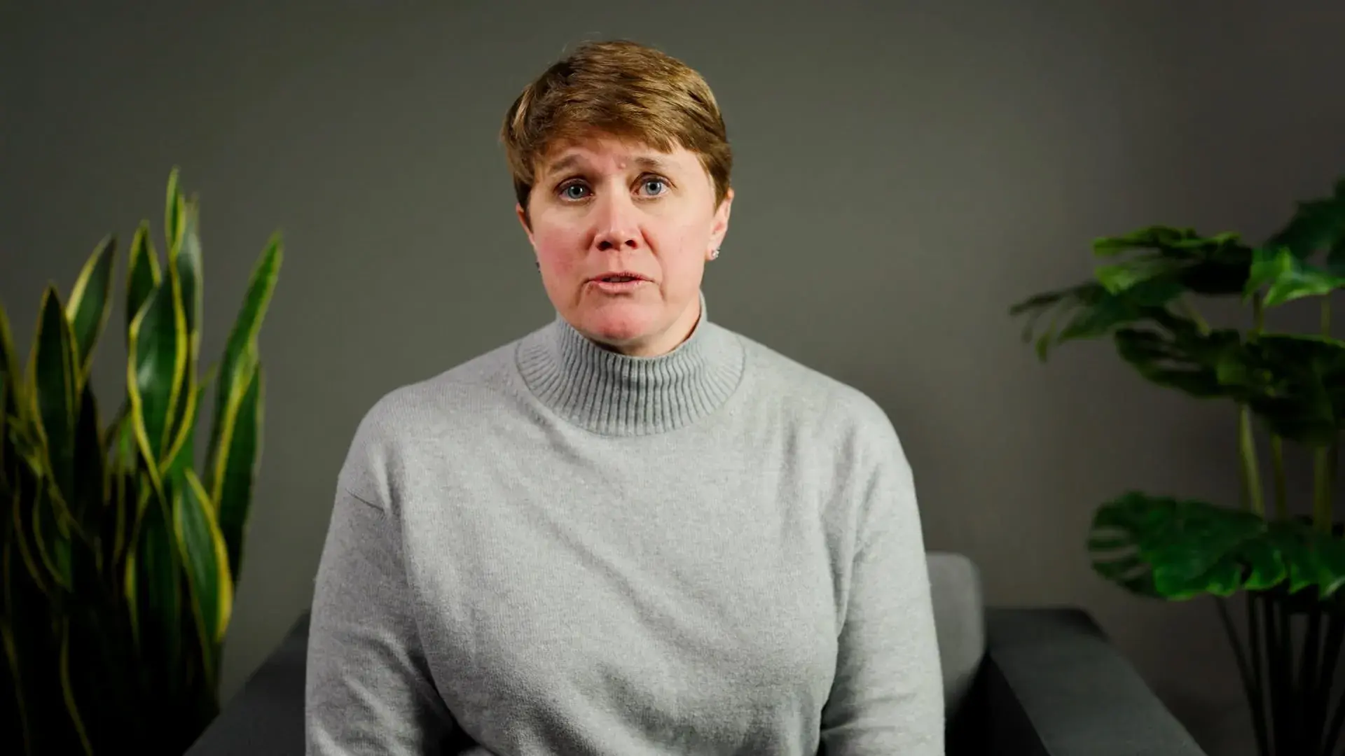 brown-haired woman in a gray sweater