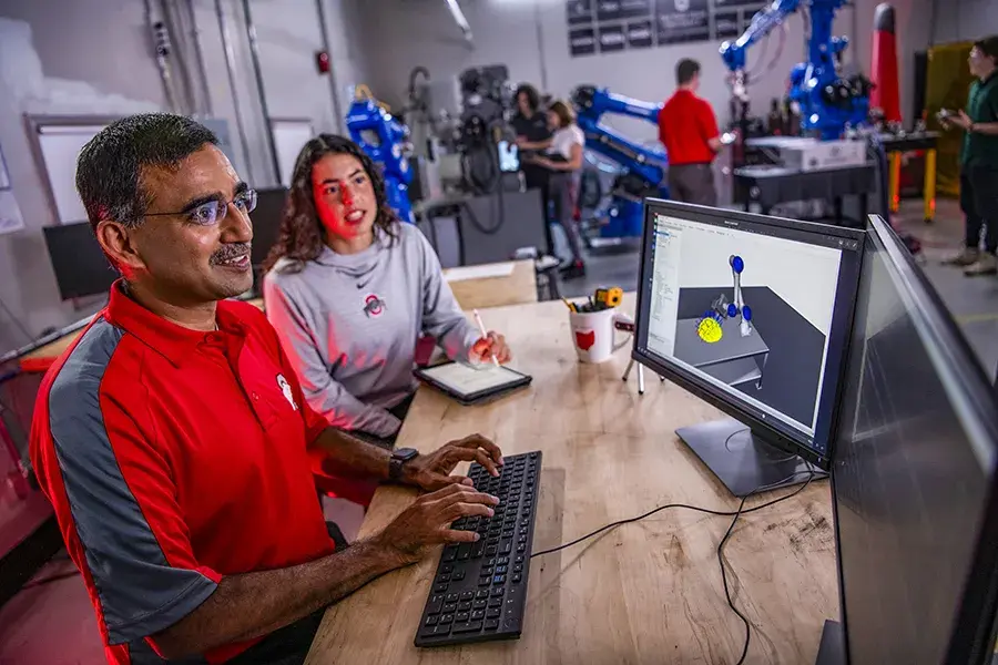 Teacher and student looking at a computer screen